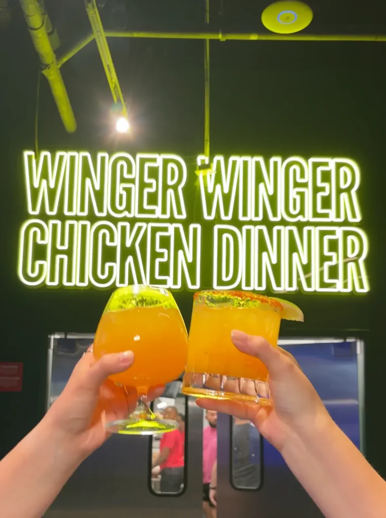 two people clinking cocktails at toca social dallas