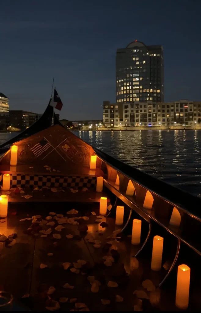 a candle lit gondola boat floating on the water at night
